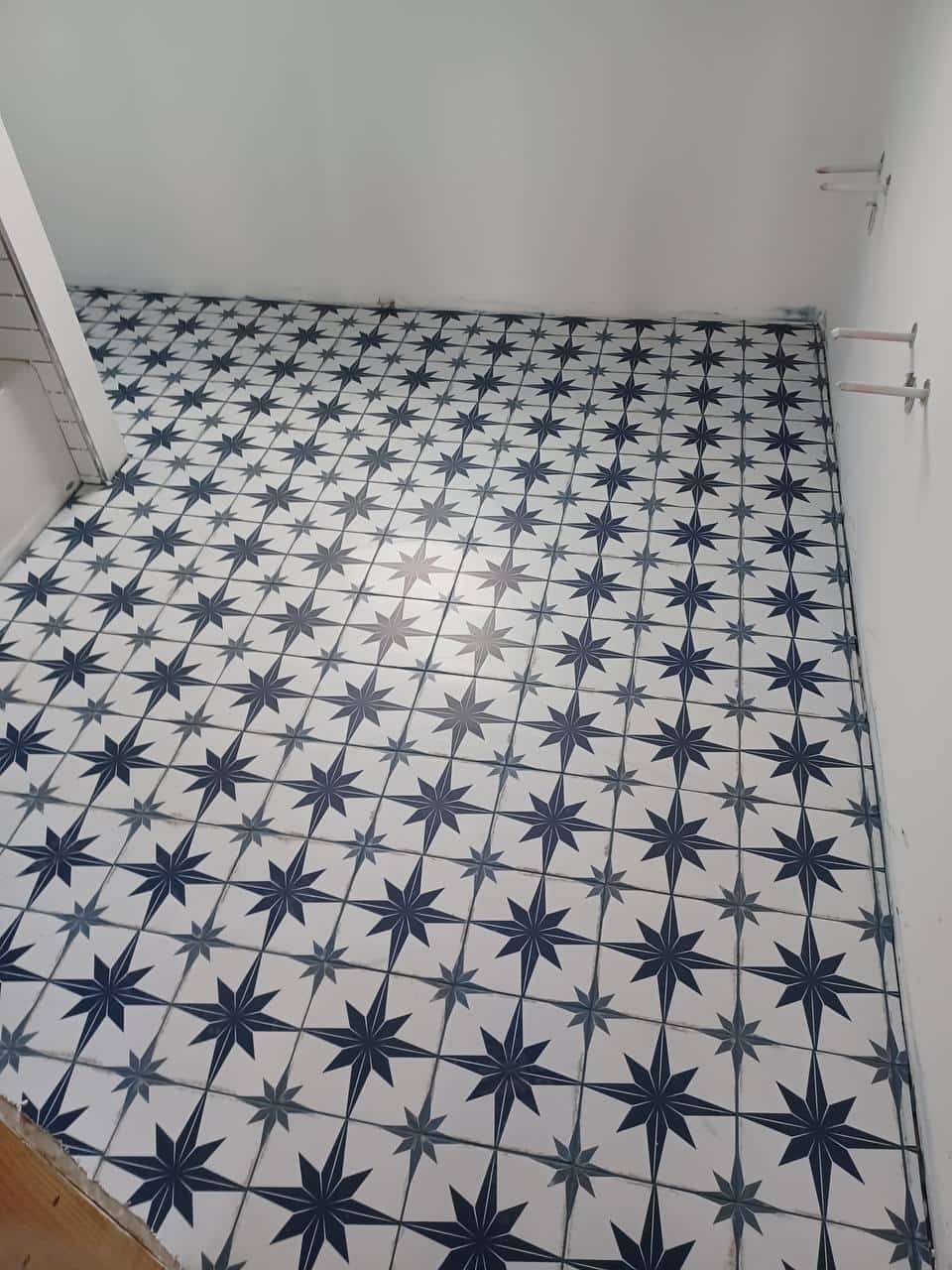 Blue and white star-pattern tile installed across a small interior floor