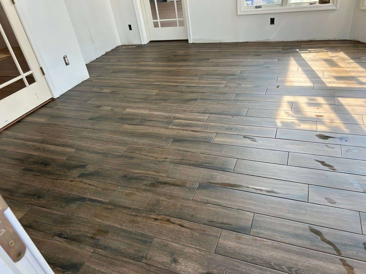 Brown wood-look plank tile installed across a bright open living area