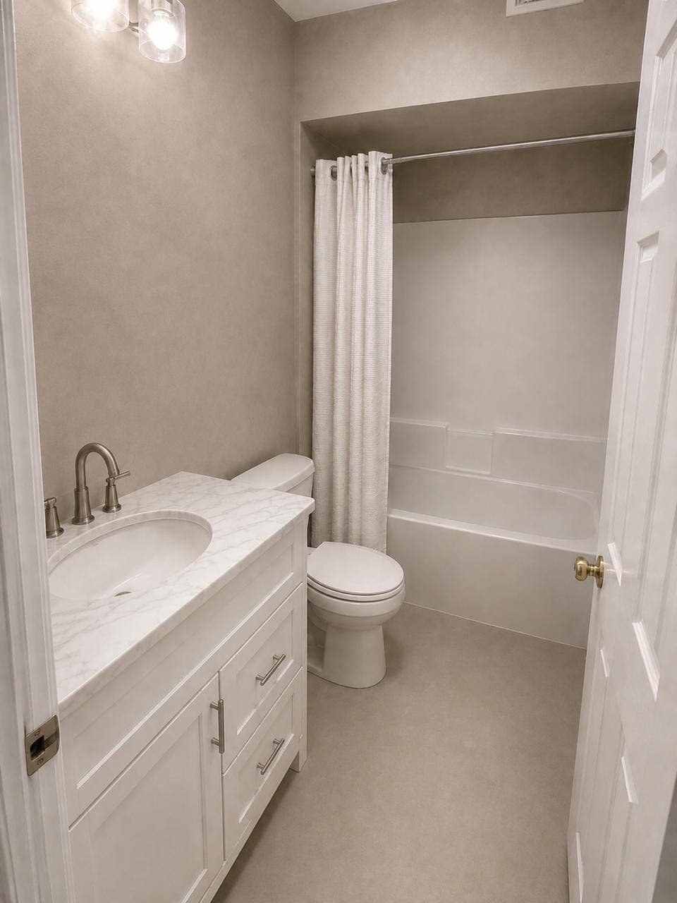 Completed white bathroom with light microcement surfaces, bathtub, vanity, and toilet