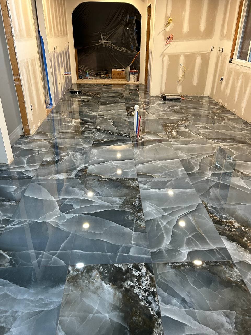 Polished black marble-look tile floor extending through an interior hallway
