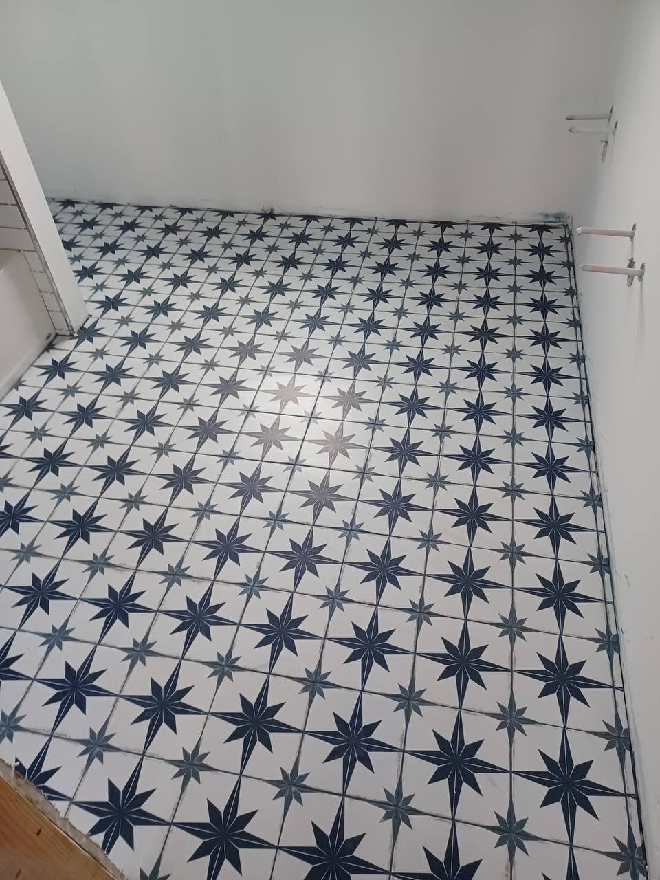 Blue and white star-pattern tile installed across a small interior floor
