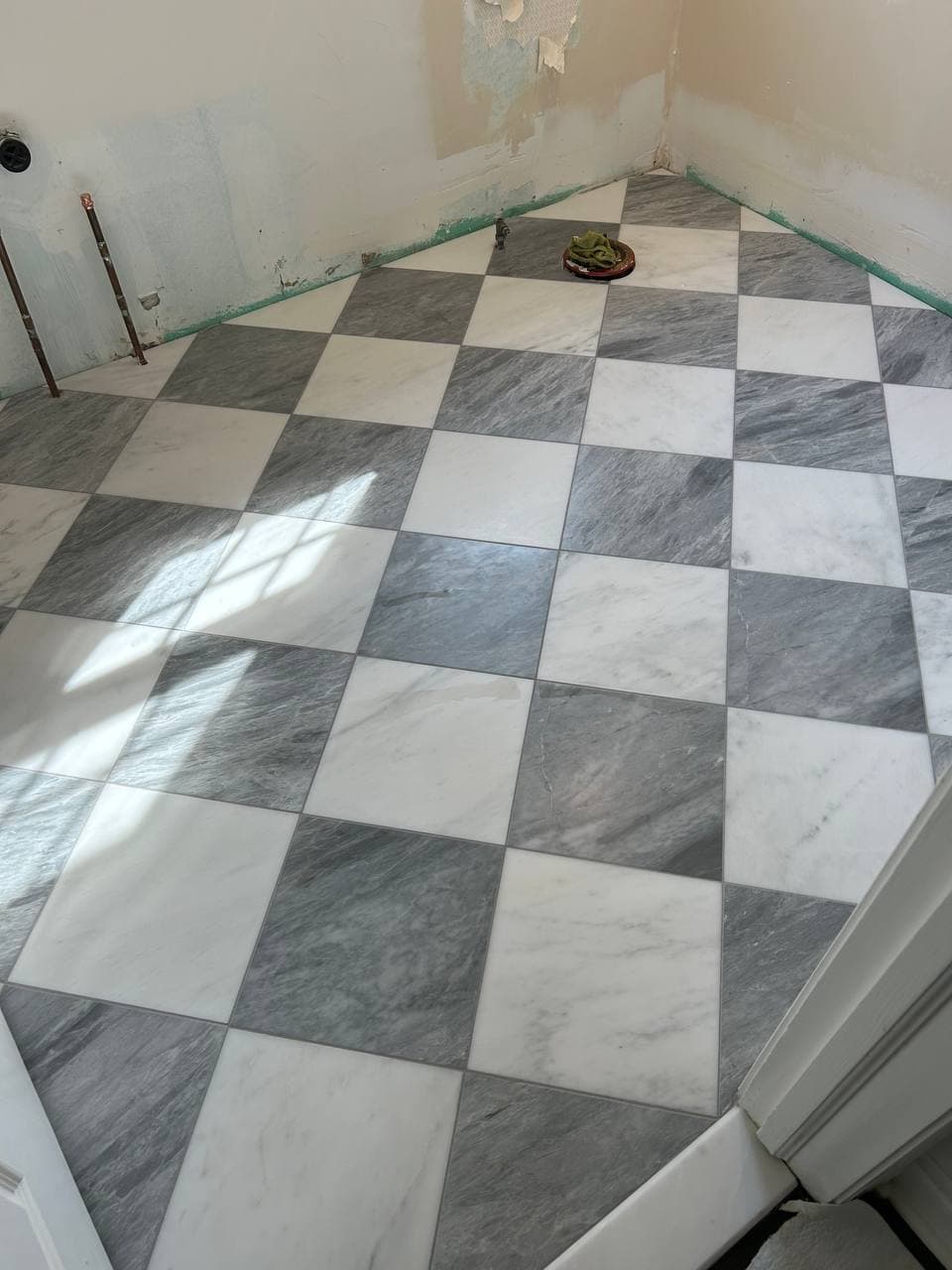Gray and white checkerboard marble-look tile installed on an interior floor