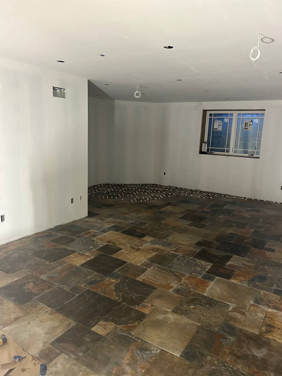 Wide room finished with multicolor slate-look square floor tile