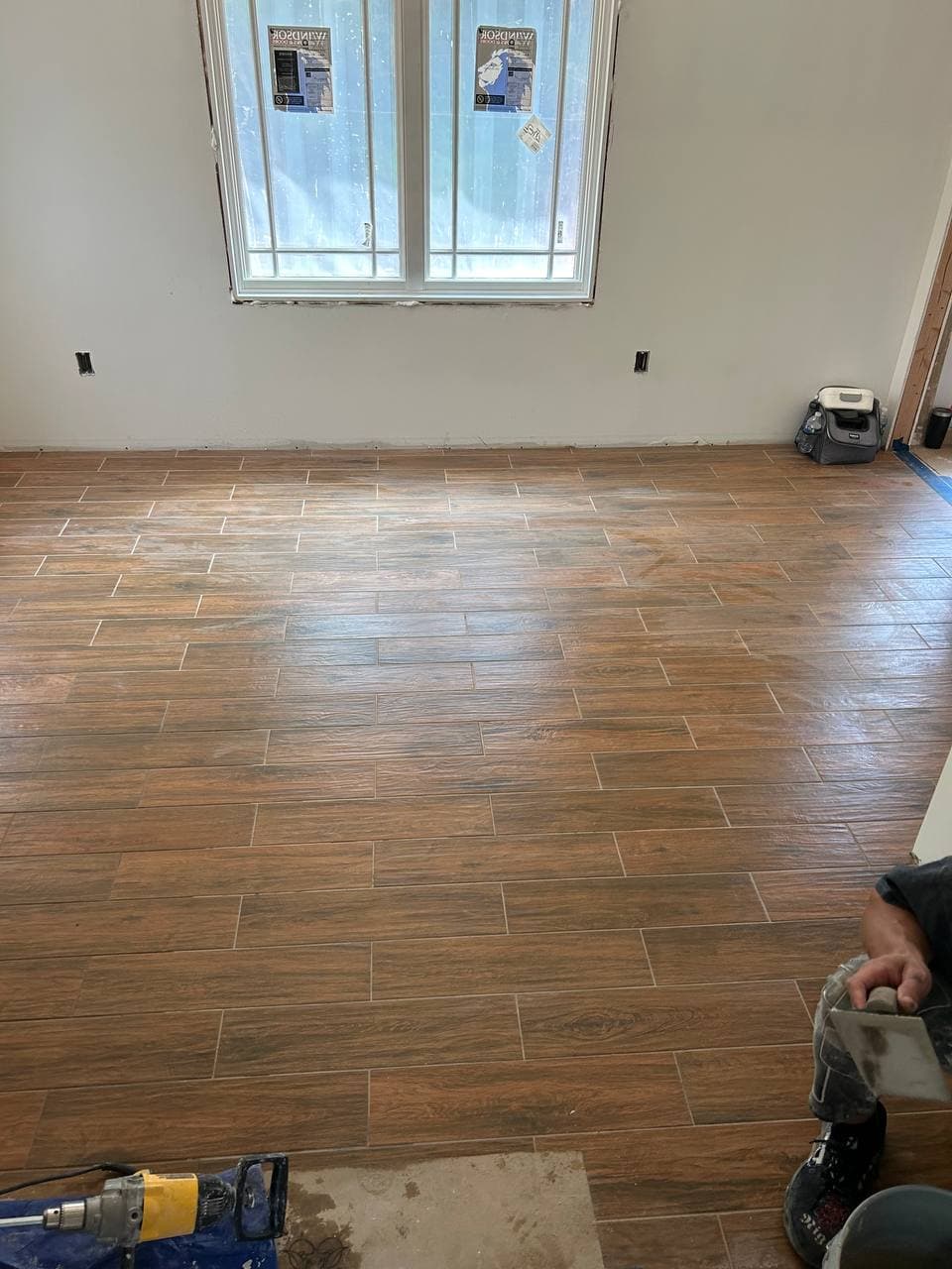 Warm wood-look plank tile covering the floor of a finished interior room